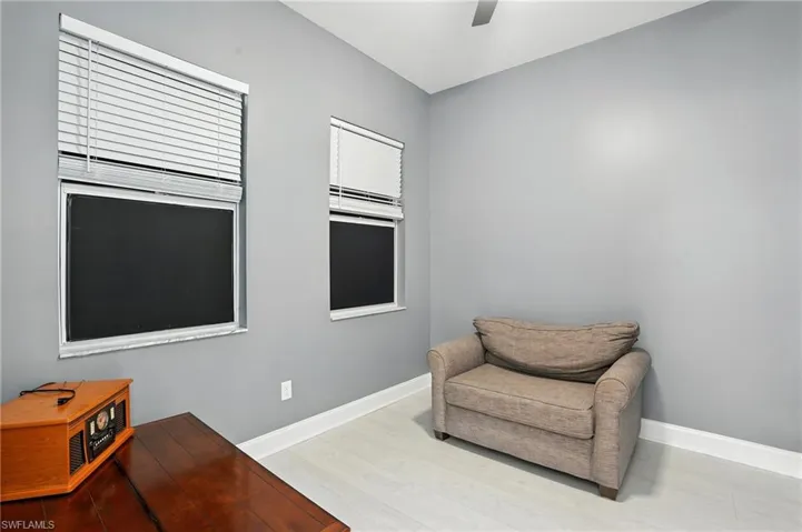 Sitting room with light wood finished floors and a ceiling fan