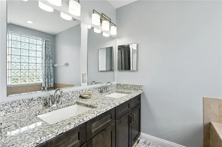Full bath with double vanity and baseboards