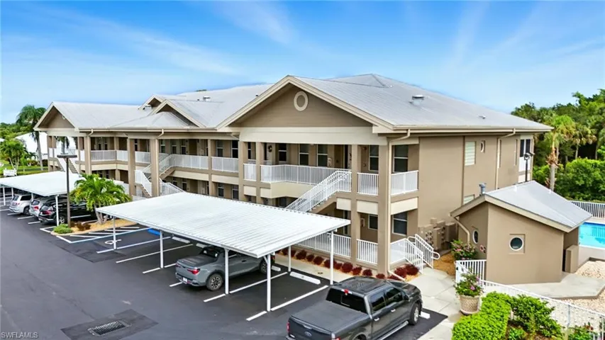 View of building exterior with stairs and covered parking