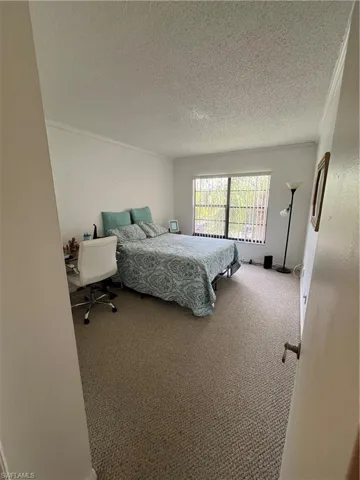 Bedroom with carpet floors and a textured ceiling