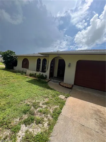Ranch-style home with a garage and a front lawn