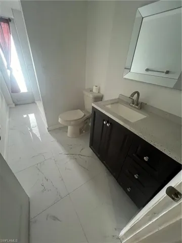 Bathroom featuring vanity, tile patterned flooring, and toilet