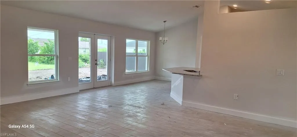 Spare room featuring light wood-style floors and a chandelier