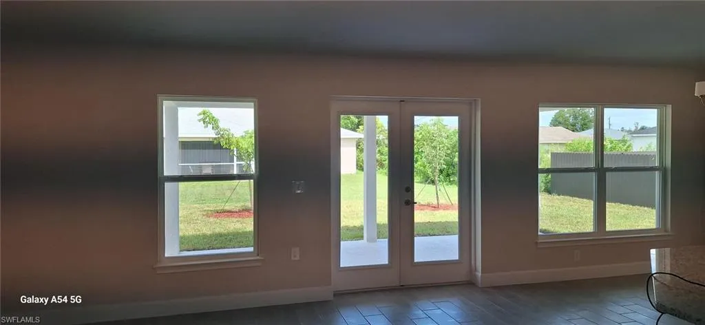 Doorway to outside with wood finished floors and french doors