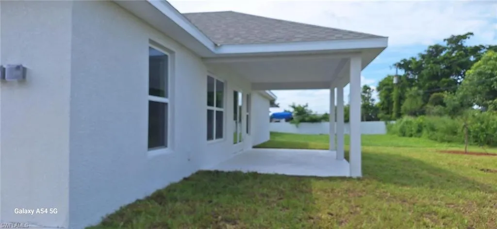 View of green lawn with a patio area