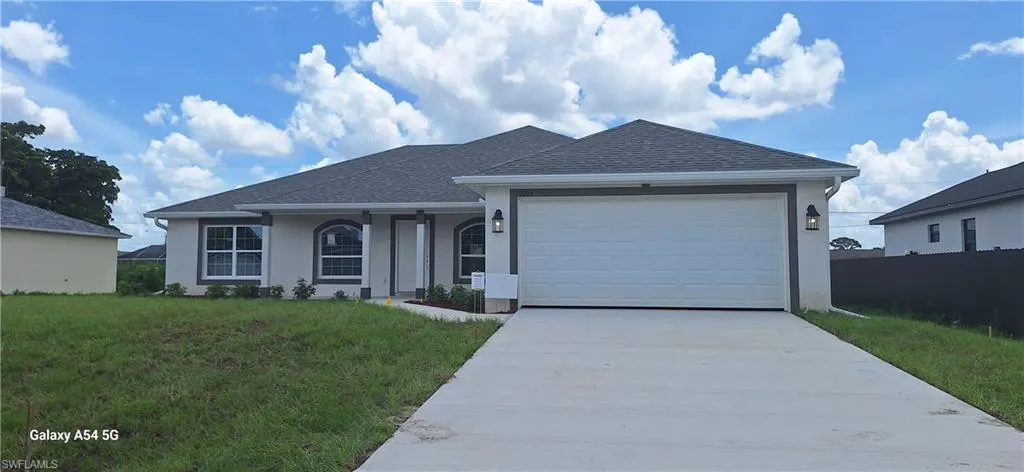Single story home featuring concrete driveway, a garage, stucco siding, and roof with shingles