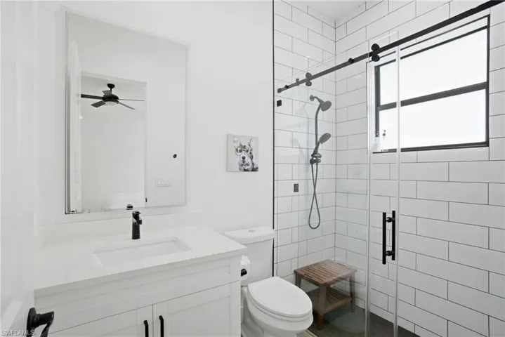 Modern bathroom featuring a white vanity with integrated sink, black faucet, and a large wall-mounted mirror