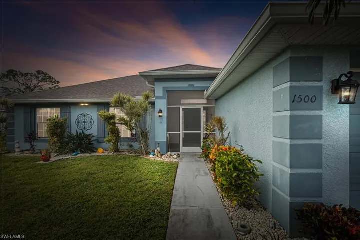 Exterior entry at dusk with a yard