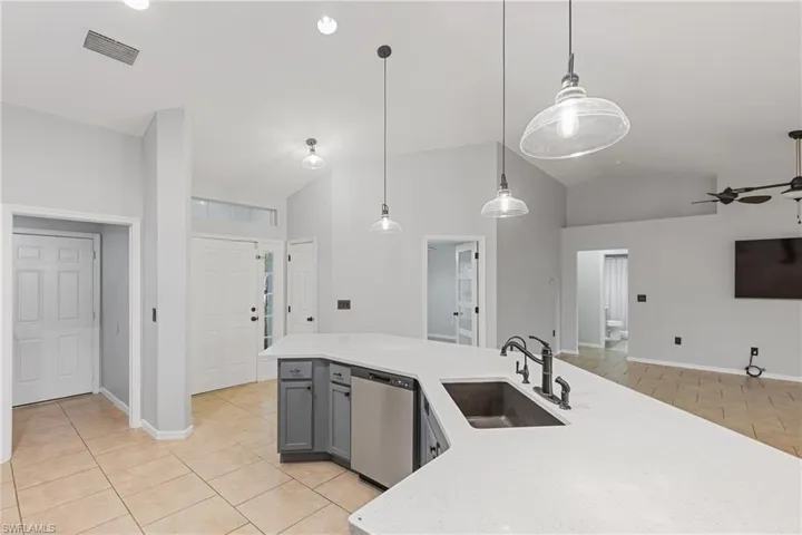 Kitchen featuring sink, pendant lighting, gray cabinets, stainless steel dishwasher, and ceiling fan