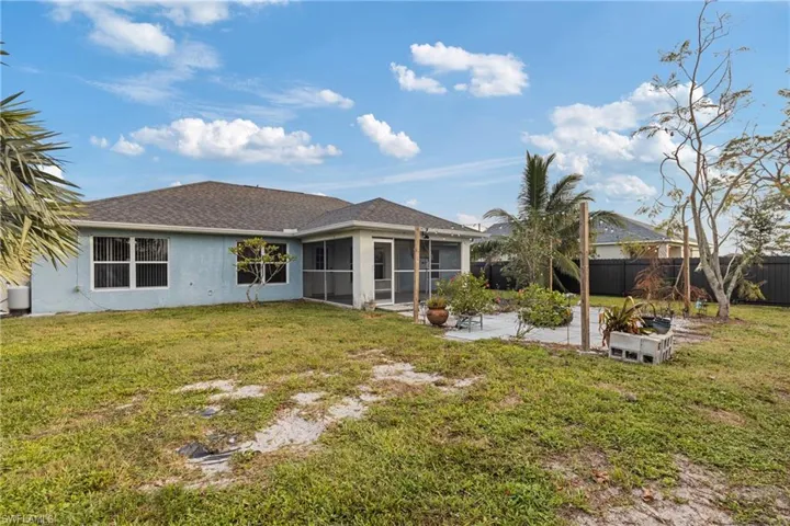Rear view of property with a patio, a sunroom, and a lawn