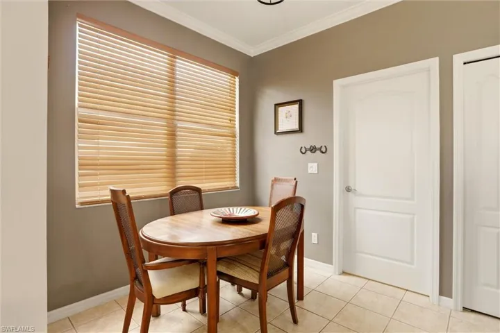Dining area with crown molding and light tile patterned floors