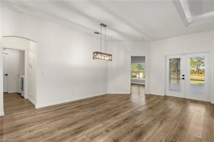 Unfurnished dining area featuring french doors, light hardwood / wood-style floors, and washer / dryer