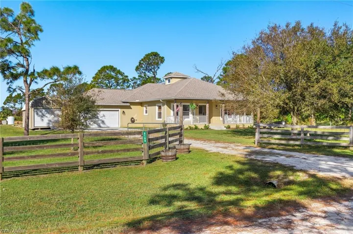 View of front of property featuring a garage, a front lawn, and a porch
