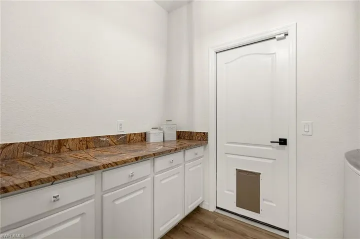 Kitchen featuring white cabinetry and light hardwood / wood-style flooring