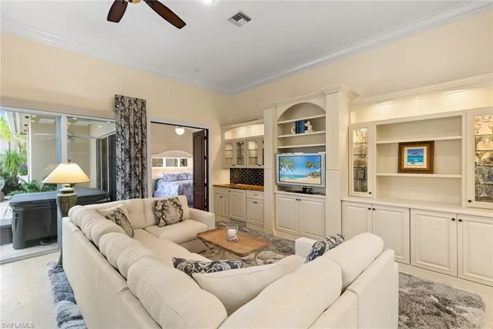 Living area with crown molding and a ceiling fan