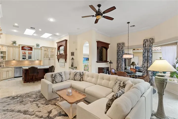 Living room with crown molding, a ceiling fan, recessed lighting, and light tile patterned floors