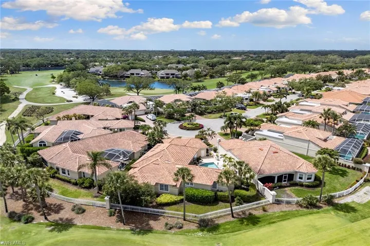 Aerial view of residential area with a golf course and a large body of water