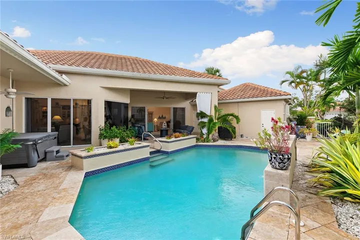Outdoor pool with a patio and a hot tub