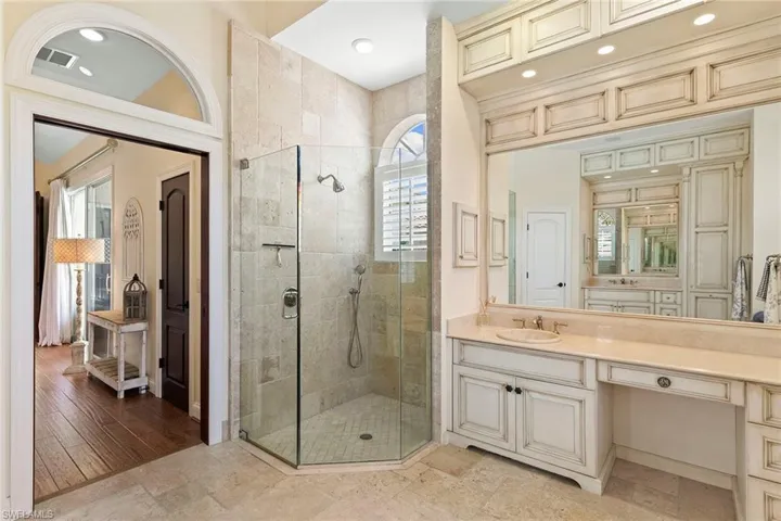 Bathroom with vanity, a stall shower, and stone tile floors