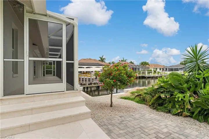Screened lanai with stairs to the side yard.