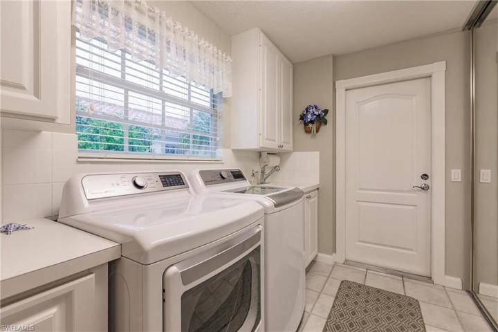 Spacious laundry room has valuable storage space and an extra closet too.