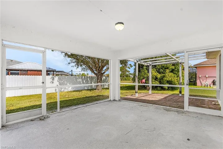 Screened-in patio with a concrete floor, overhead lighting, and an exterior brick paver patio