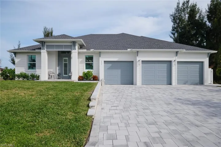 View of front of property featuring a front yard and a garage