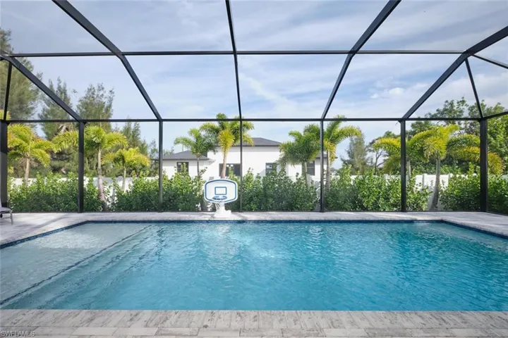 View of pool featuring screen enclosure