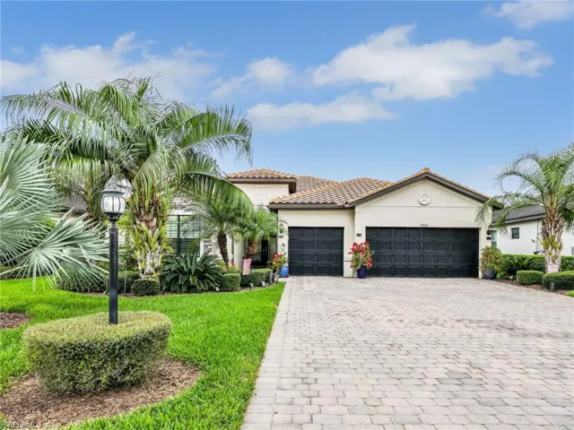 Mediterranean / spanish-style home featuring stucco siding, a garage, decorative driveway, a front lawn, and a tile roof
