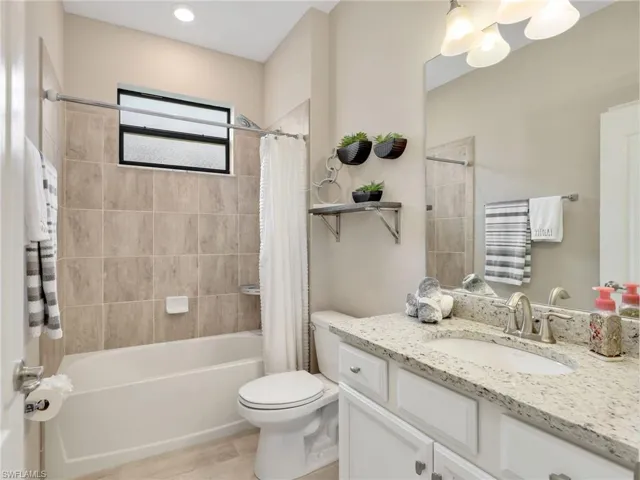 Bathroom with shower / bath combo with shower curtain and vanity