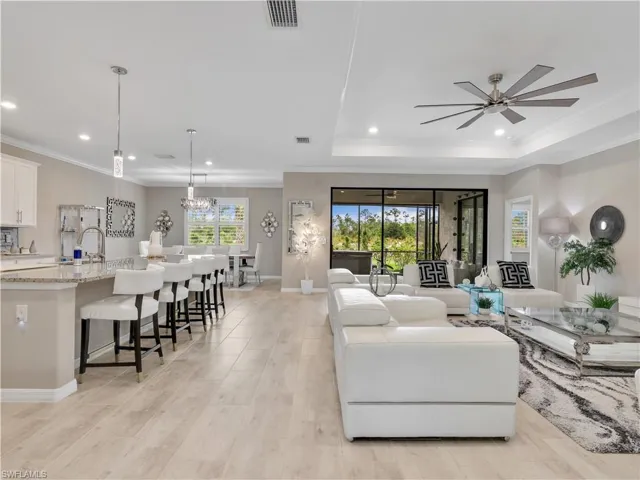 Living area featuring ornamental molding, recessed lighting, and a tray ceiling