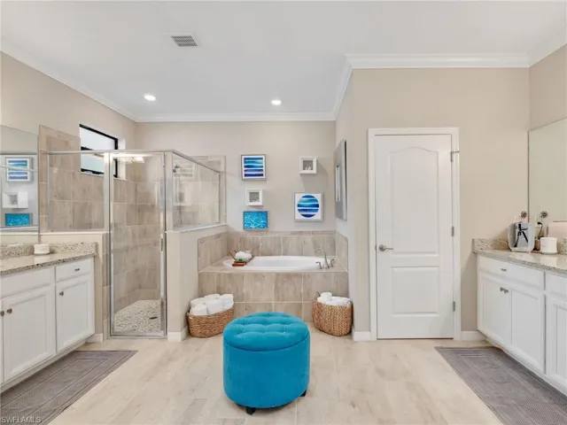 Bathroom with vanity, a stall shower, a bath, ornamental molding, and recessed lighting