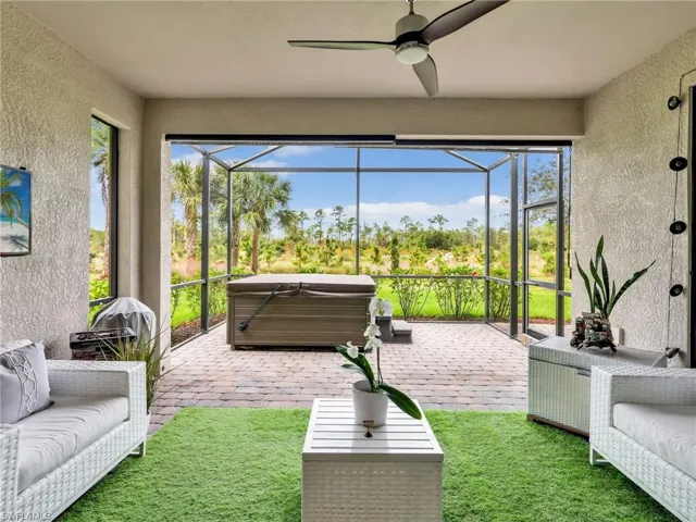 Sunroom / solarium with a hot tub, a patio area, a ceiling fan, and plenty of natural light