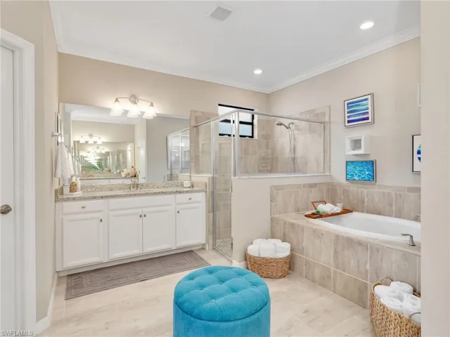 Bathroom with vanity, a bath, a shower stall, ornamental molding, and light wood-style flooring