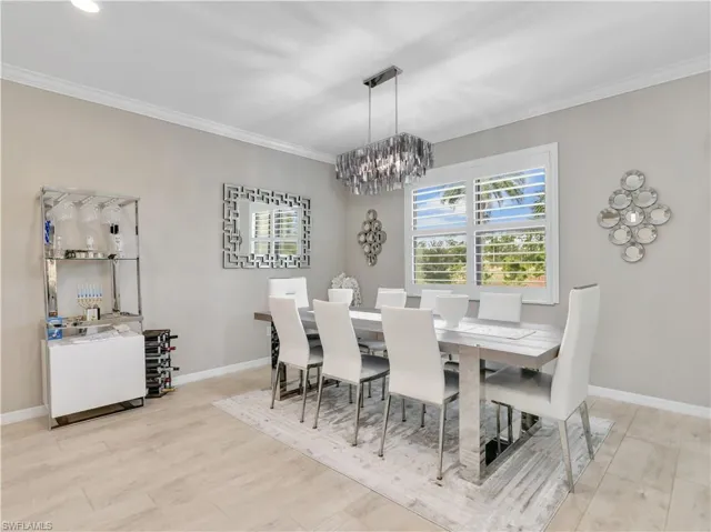 Dining space with crown molding and a chandelier