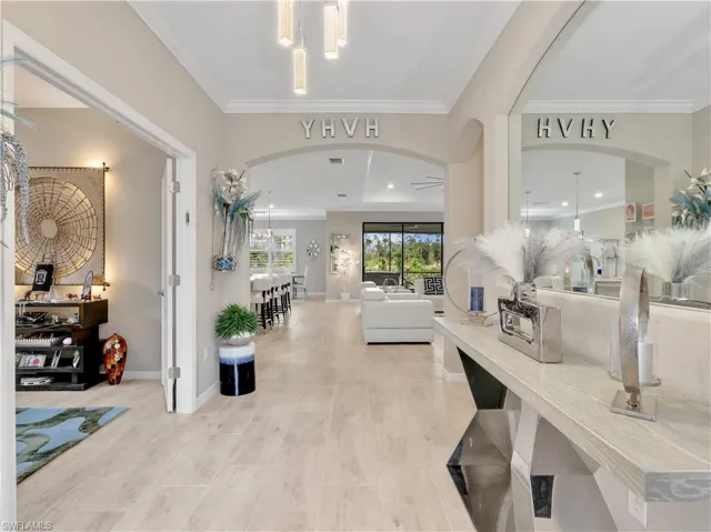 Foyer with arched walkways and ornamental molding