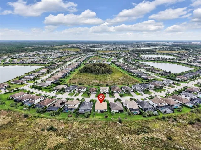 Aerial view of property and surrounding area with a nearby body of water and nearby suburban area