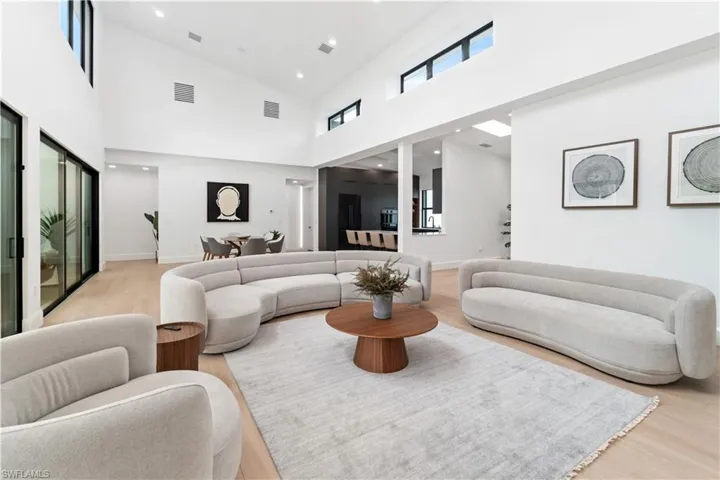 Living room featuring light wood-type flooring and high vaulted ceiling