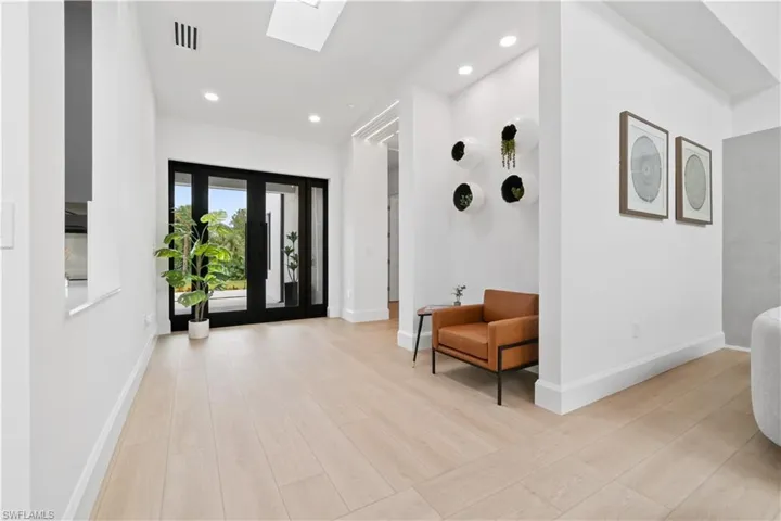 Entrance foyer with light hardwood / wood-style floors and a skylight