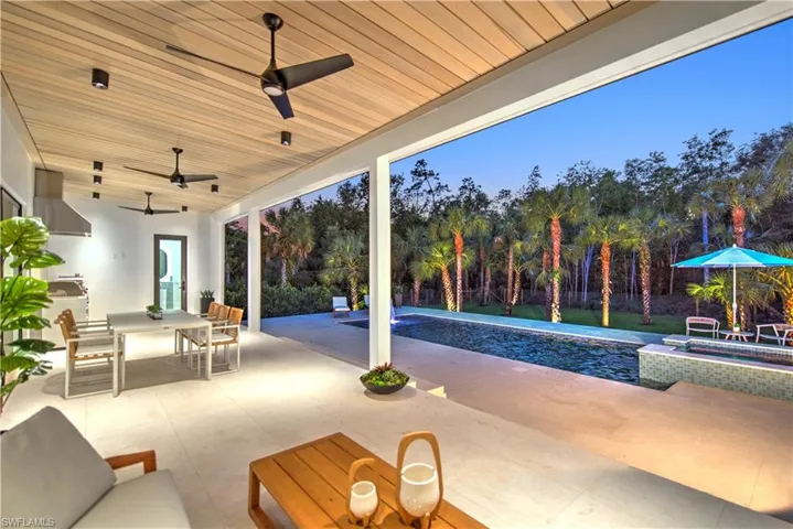 View of patio / terrace with ceiling fan and a pool with hot tub