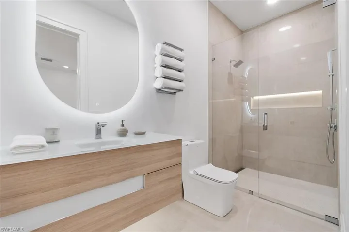 Bathroom with tile patterned floors, toilet, and a tile shower