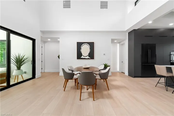 Dining area featuring light hardwood / wood-style floors and a high ceiling