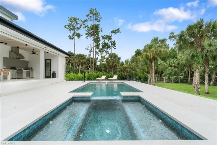 View of patio / terrace with ceiling fan and a pool with hot tub