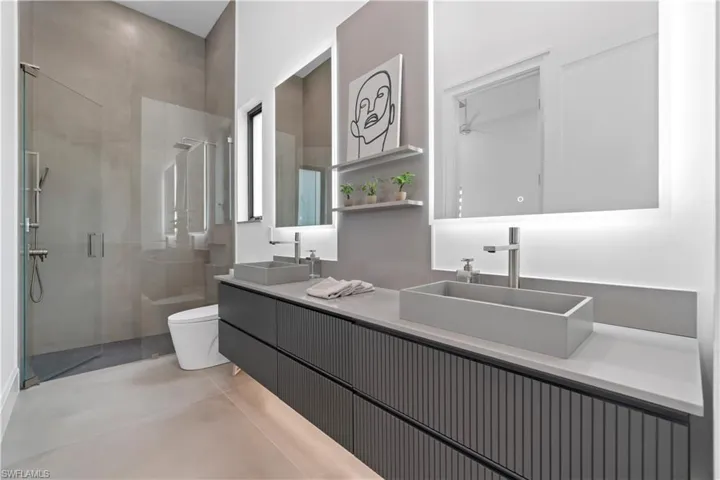 Bathroom with toilet, walk in shower, and vanity