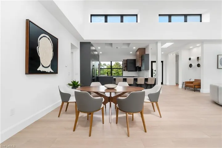 Dining room featuring a towering ceiling and light hardwood / wood-style flooring