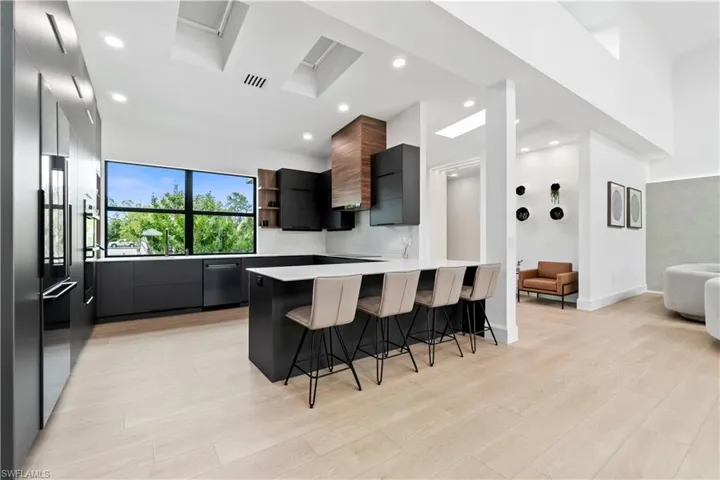 Kitchen featuring kitchen peninsula, stainless steel appliances, light hardwood / wood-style floors, and a breakfast bar