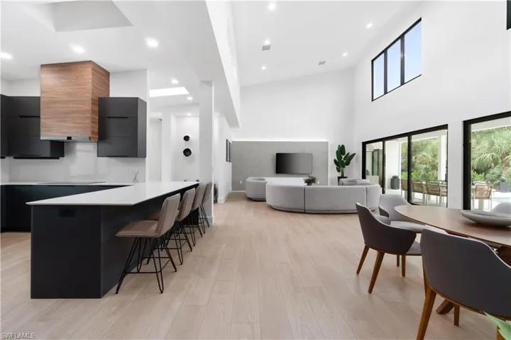 Kitchen featuring a breakfast bar area, light hardwood / wood-style flooring, a high ceiling, and a kitchen island