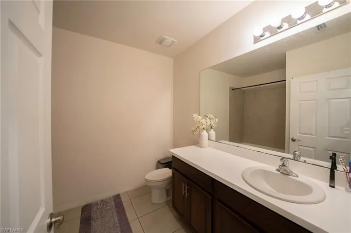 Bathroom featuring visible vents, walk in shower, tile patterned floors, vanity, and toilet