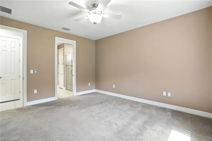 Unfurnished bedroom featuring light carpet and a ceiling fan