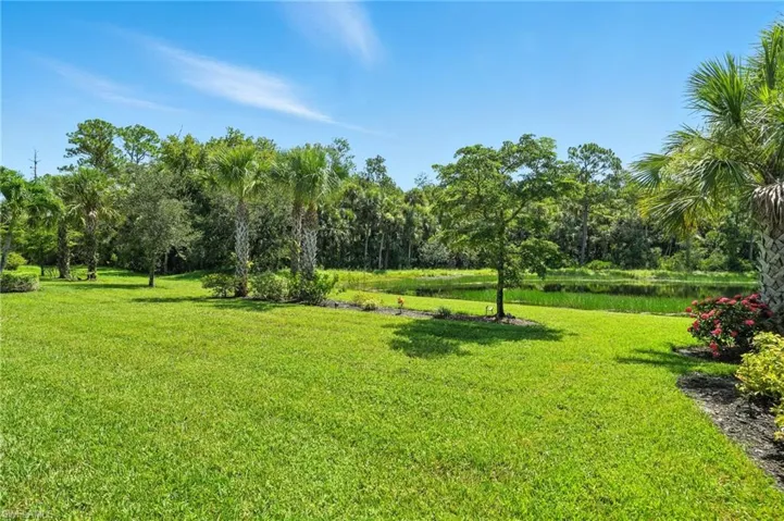 Surrounding community with a water view and a lawn